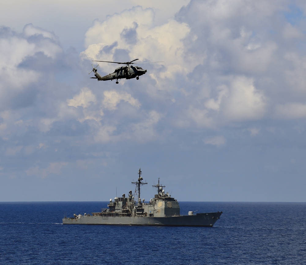 Sikorsky Multi-role helicopter and USS Normandy, a Ticonderoga class Destroyer during the ongoing Exercise Malabar-2015