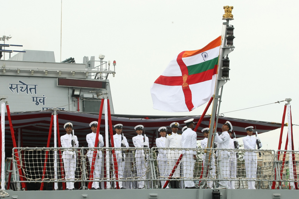 Ceremonial Colour Guard hoisting the Naval ensign for the first time on board INS Sumitra